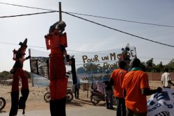 Activists on stilts dressed as bolt cutters