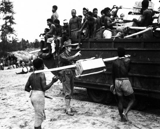 Aitape, Papua Neuguinea,  August 1944: Auf Befehl weißer Offiziere mussten die Insulaner alles, was die kriegführenden  Armeen brauchten, über glitschige Pfade ins umkämpfte Gebirge Neuguineas schleppen.